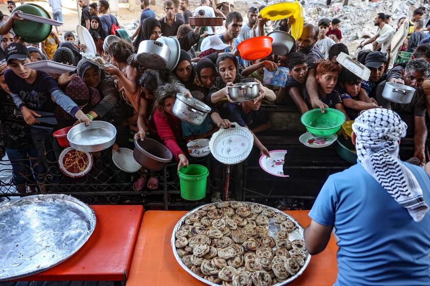 Gaza, famiglie palestinesi attendono pasti preparati da volontari